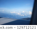 Serene Aerial View of Fluffy Clouds from Airplane Window Focus on Background 129712121
