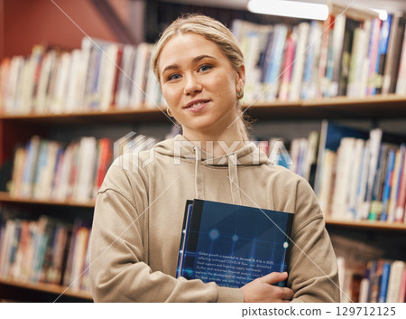 Face, woman and student in university library ready for learning. Education, portrait and happy female from Canada standing by bookshelf with book for studying, knowledge and literature research. Face, woman and student in university library ready for learning. Education, portrait and happy female from Canada standing by bookshelf with book for studying, knowledge and literature research. 129712125