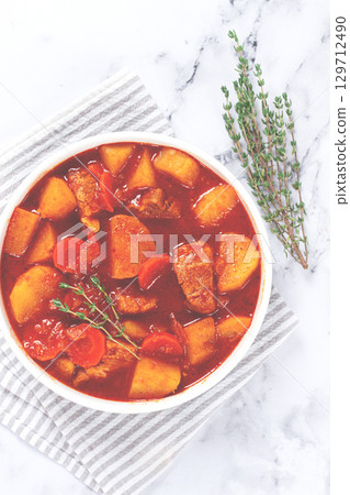 meat goulash with potatoes and carrots, sweet peppers, in a saucepan, top view, traditional Hungarian soup, homemade, no people, 129712490