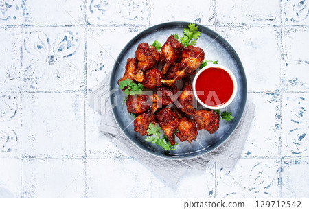 Crispy golden potatoes topped with  onions and herbs served in a rustic bowl 129712542
