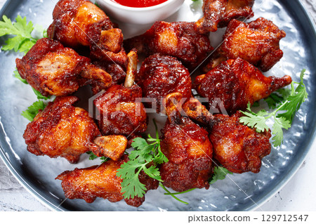 Crispy pieces of fried chicken, on a plate with sauce and herbs, in a modern kitchen environment, there are no people Crispy pieces of fried chicken, on a plate with sauce and herbs, in a modern kitchen environment, there are no people 129712547