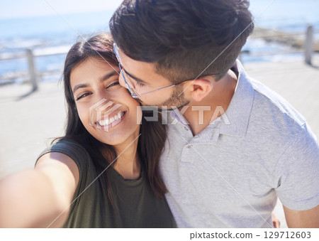 Couple, love and selfie at the beach, travel and kiss by ocean with support, trust and care with adventure in Mumbai. Smile in picture, happy and memory with smartphone photography for romance Couple, love and selfie at the beach, travel and kiss by ocean with support, trust and care with adventure in Mumbai. Smile in picture, happy and memory with smartphone photography for romance 129712603