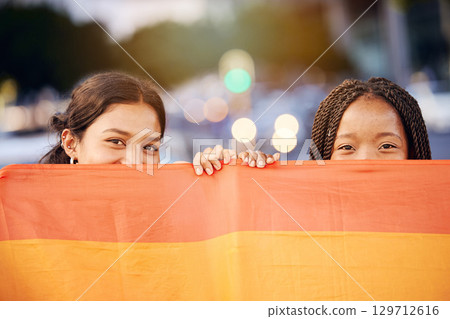 Love, pride flag and portrait of a lesbian couple at a LGBTQ, freedom or community parade in the city. Happy, celebration and interracial gay women with commitment at a LGBT, rainbow sexuality event. 129712616