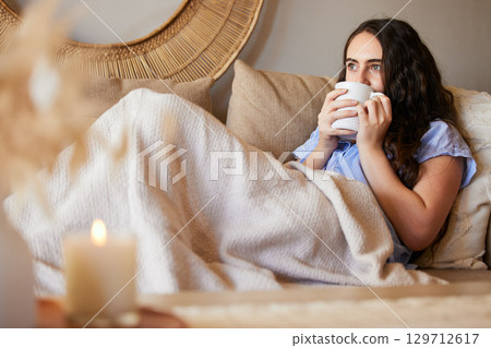 Woman with coffee, relax on sofa with peace and calm at home, wellness and morning routine. Content with coffee cup in living room, female chill with drink with satisfaction and self care 129712617