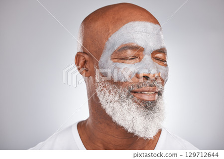 Skincare, beauty or senior black man with face mask marketing or advertising a luxury beauty product for self care. Studio background, facial cosmetics or African old man relaxing with a happy smile 129712644