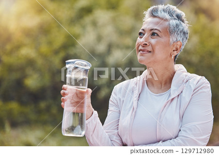 Face, water bottle and senior woman in nature on break after sports workout, exercise or training. Thinking, drinking water and retired female from India with liquid for hydration, health or wellness 129712980