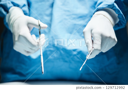 Doctor hands, gloves and surgery tools in closeup for healthcare, wellness or hospital job. Medic, health expert or professional with scissor, scalpel or ppe for safety, medical job or work in clinic 129712992