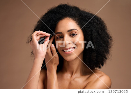 Face, makeup and eyebrow pencil with a model black woman in studio on a brown background for a beauty product. Portrait, cosmetics and eyes with an attractive female inside to apply a cosmetic brand 129713035