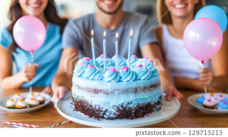 Group celebrating birthday with colorful cake, balloons, and festive atmosphere in bright setting 129713213
