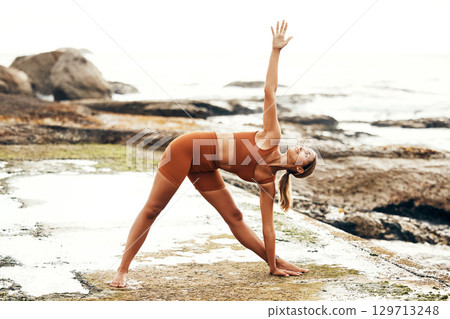 Yoga, balance and fitness with woman at the beach, pilates and zen in nature with exercise and body care outdoor. Workout by the ocean, stretching and peace with mindset and motivation for wellness. 129713248