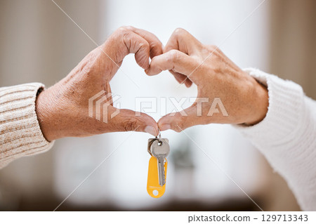 Senior couple, heart hands and keys for new home, success and bonding with love, care and support. Closeup, elderly people and hand sign together in house, apartment or home with excited homeowner 129713343