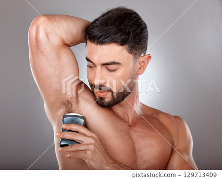 Man, beauty and deodorant for armpit, hygiene and grooming with cosmetic product and body care. Wellness, skincare and clean fresh lifestyle, healthy skin with cosmetics against studio background 129713409