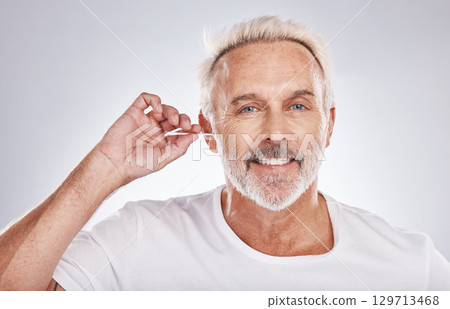 Senior man, cotton bud and ear cleaning happy portrait in white studio background for grooming hygiene, healthy wellness and wax removal. Elderly model, cosmetics ears cleaner and body care happiness 129713468