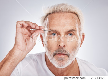 Man, face or eyebrow tweezing grooming on gray studio background for self care, healthcare wellness or beauty aesthetic. Portrait, mature model or hair removal tweezer in cleaning growth maintenance 129713479