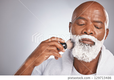 Face, shaving cream and black man with brush on beard, skincare spa treatment on grey background. Health, mock up and facial hair, mature man morning shave routine with space for product placement. 129713486