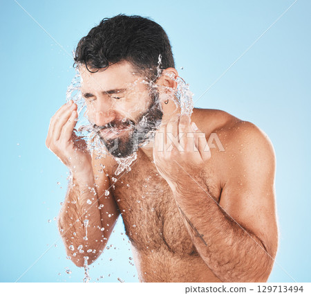 Man, water splash face and cleaning in studio for wellness, health and self care groom by blue background. Model, bathroom and water with hands for healthy facial, self love and cosmetics by backdrop Man, water splash face and cleaning in studio for wellness, health and self care groom by blue background. Model, bathroom and water with hands for healthy facial, self love and cosmetics by backdrop 129713494