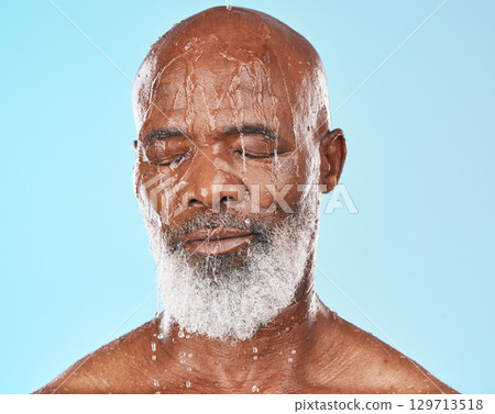 Shower, black man and water for cleaning, skincare and wellness on blue studio background. Mature male, elderly guy and face wet for hygiene, washing or body care for beauty, cosmetics or clear skin Shower, black man and water for cleaning, skincare and wellness on blue studio background. Mature male, elderly guy and face wet for hygiene, washing or body care for beauty, cosmetics or clear skin 129713518