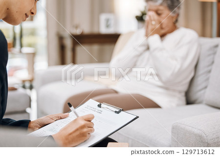 Psychologist, consulting or old woman crying in counseling with therapist writing notes in conversation. Stressed, checklist or psychology expert listening or helping sad senior person in therapy 129713612