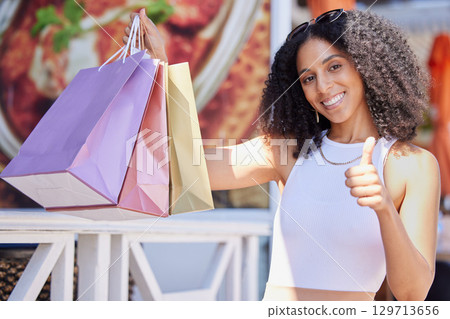 Black woman, shopping and thumbs up with a smile and happiness about sale, discount or promotion with paper bags outdoor. Portrait of female with hand for thank you, advertising and deal on product 129713656