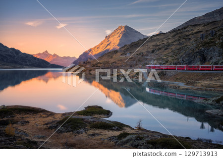 Aerial view of Bernina Express train near lake in the Swiss Alps Aerial view of Bernina Express train near lake in the Swiss Alps 129713913