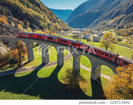 Aerial view of the red Bernina Express train on Brusio Viaduct Aerial view of the red Bernina Express train on Brusio Viaduct 129713942