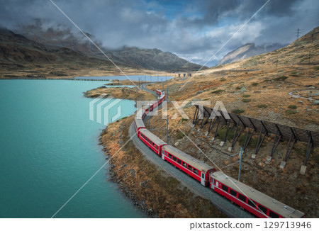 Aerial view of Bernina Express train near lake in Switzerland Aerial view of Bernina Express train near lake in Switzerland 129713946