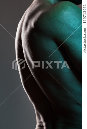 Man, body or muscles on dark studio background and blue light aesthetic, fitness goals or workout progress. Zoom, back skin or bodybuilder model and exercise, training or healthcare wellness strength 129713951