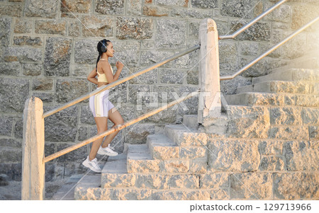 Fitness, podcast or woman running on steps for cardio workout, training or body exercise at sunrise in summer. Brazil, wellness or girl athlete exercising or walking on stairs streaming radio music 129713966
