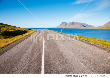 Empty road leading along the coast. Typical Icelandic landscape. 129714042