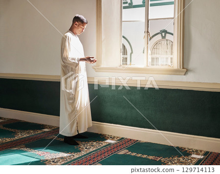 Muslim, prayer or man in a mosque praying to Allah for spiritual mindfulness, support or wellness in Doha, Qatar. Religion, peace or Islamic person in temple to worship or praise God with gratitude 129714113
