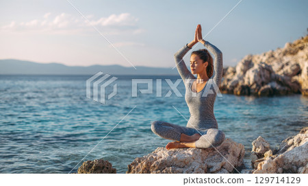 A peaceful scene of a woman practicing yoga by the calm blue sea at sunset. Captures moments of mindfulness, relaxation, and wellness, perfect for health and spiritual themes 129714129