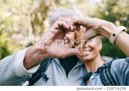 Heart, love hands and senior couple outdoors on vacation, holiday or hiking trip. Affection sign, romance emoji and elderly interracial couple, man and woman bonding together in nature on a hike. 129714239