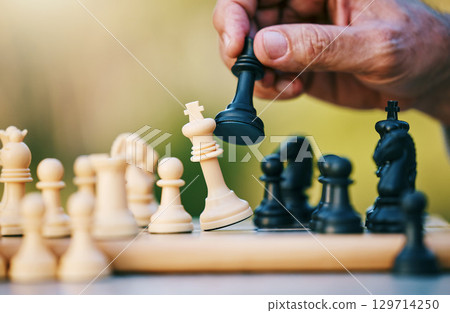 Chess, play or hand with a king on a board game with a winning strategy in a tournament outdoors in nature. Checkmate, mindset or smart man playing in a sports contest or problem solving challenge Chess, play or hand with a king on a board game with a winning strategy in a tournament outdoors in nature. Checkmate, mindset or smart man playing in a sports contest or problem solving challenge 129714250