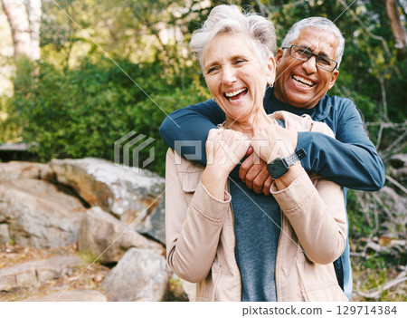 Hiking, laugh and romance with a senior couple hugging while in the woods or nature forest together in summer for a hike. Fun, joke and bonding with a mature man and woman enjoying retirement outdoor Hiking, laugh and romance with a senior couple hugging while in the woods or nature forest together in summer for a hike. Fun, joke and bonding with a mature man and woman enjoying retirement outdoor 129714384