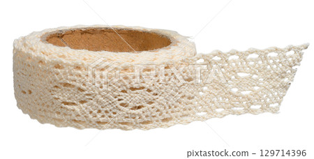 Close-up of beige knitted ribbon with lace pattern rolled into a roll on cardboard base. Isolated background 129714396