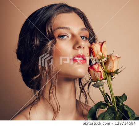 Beauty, flowers and face of woman in studio for wellness, fashion and skincare on brown background. Makeup, cosmetics and female model with roses for beauty salon, natural self care and spa aesthetic Beauty, flowers and face of woman in studio for wellness, fashion and skincare on brown background. Makeup, cosmetics and female model with roses for beauty salon, natural self care and spa aesthetic 129714594