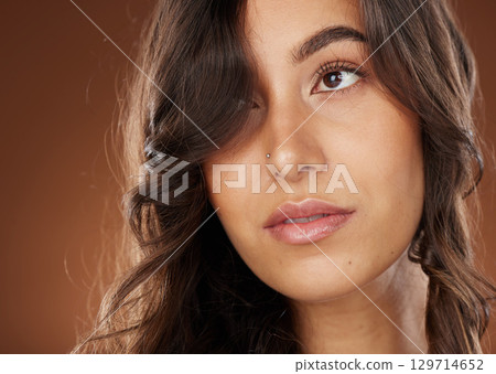 Hair, beauty and skincare with a model woman in studio on a brown background for natural or keratin treatment. Face, haircare and salon with an attractive young female posing to promote a product Hair, beauty and skincare with a model woman in studio on a brown background for natural or keratin treatment. Face, haircare and salon with an attractive young female posing to promote a product 129714652