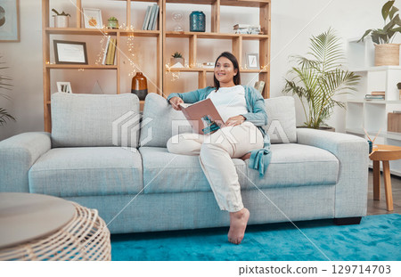Pregnant woman, sofa and book for reading, idea or thinking for vision, planning or inspiration in living room. Mother, books and goals for success to relax, rest and smile on lounge couch in Atlanta 129714703