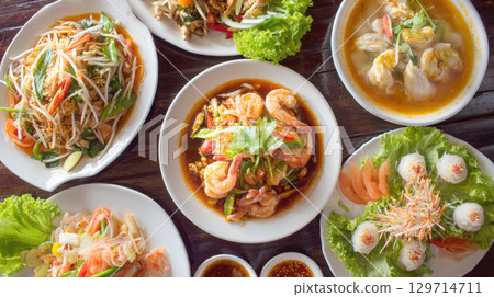 vibrant top-down view of a traditional Thai feast, perfect for restaurant menus, food blogs, or culinary travel content. The diverse, colorful dishes showcase rich and bold flavors of Asian cuisine 129714711