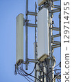 Sector antennas and microwave radio relay link equipment are installed on a telecommunication tower, providing wireless communication services against a clear blue sky 129714755