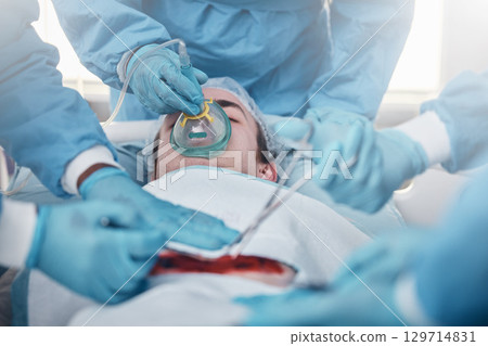 Doctors, surgery and oxygen with a medicine team in scrubs operating on a man patient in a hospital. Doctor, nurse and teamwork with a medical group in a clinic to perform an operation Doctors, surgery and oxygen with a medicine team in scrubs operating on a man patient in a hospital. Doctor, nurse and teamwork with a medical group in a clinic to perform an operation 129714831