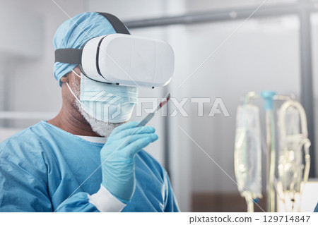 Virtual reality, medical and doctor with a surgery simulation in operation room in the hospital. Vr, healthcare and male surgeon practicing and analyzing the human anatomy with futuristic device. 129714847