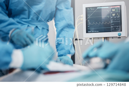Hands, monitor and operation with a team of doctors at work during surgery with equipment or a tool in a hospital. Doctor, nurse and collaboration with a medicine professional group saving a life 129714848