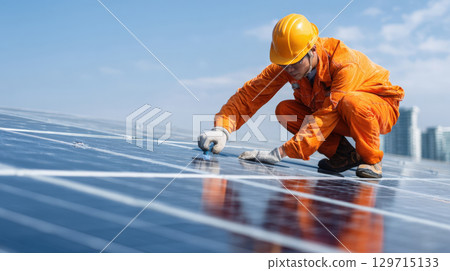professional worker wearing safety gear is installing or maintaining solar panels on a rooftop. The focus is on renewable energy and sustainable technology for a green future 129715133