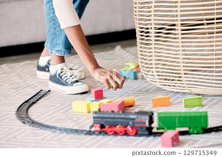 Mother, cleaner or babysitter woman hands cleaning kids toys and mess in a living room. Helping nanny or mom with care in a family house clean children play toy off the floor carpet in a home lounge 129715349
