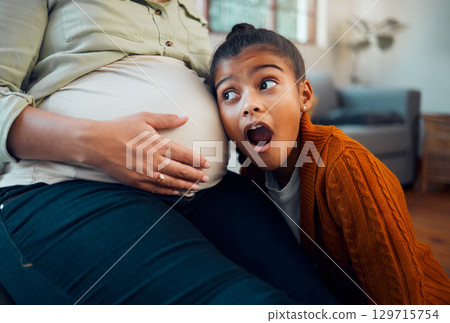 Pregnancy, family and girl with ear to pregnant belly with wow, shock and surprise expression on face. Love, family home and excited child with pregnant mother listening to baby heartbeat on stomach Pregnancy, family and girl with ear to pregnant belly with wow, shock and surprise expression on face. Love, family home and excited child with pregnant mother listening to baby heartbeat on stomach 129715754