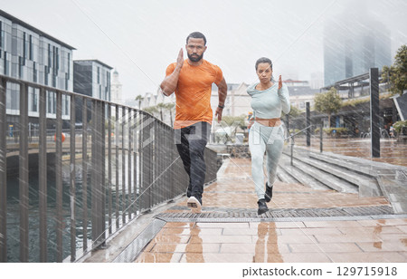 Fitness, city and couple in the rain running for workout, marathon training and exercise in winter. Sports, wellness and man and woman run for endurance, challenge and body performance in urban town 129715918