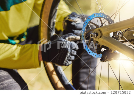 Hands of man on bicycle wheel while outdoor for cycling with mountain bike to fix puncture, tire maintenance and repair in nature. Athlete doing inspection before training, adventure and travel 129715932