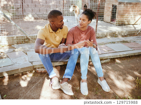 Black couple, sit and love in animal shelter, homeless canine center or foster care kennel in adoption decision choice. Talking, black woman and bonding man in pet dog charity or volunteer community 129715988