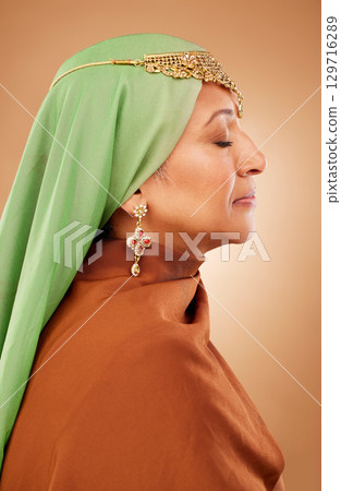 Muslim, culture clothes and senior woman with jewelry, faith and hijab against a brown studio background. Islamic fashion, traditional and modest burka model with religion, spiritual and scarf Muslim, culture clothes and senior woman with jewelry, faith and hijab against a brown studio background. Islamic fashion, traditional and modest burka model with religion, spiritual and scarf 129716289